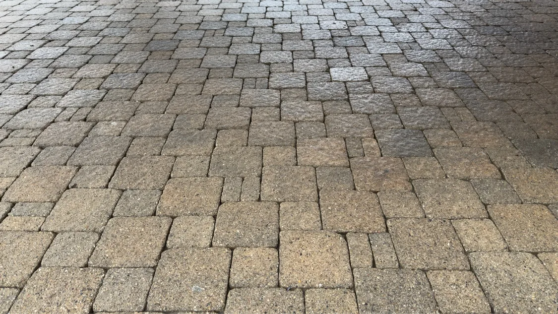 Close-up of clean tan paver patio after pressure washing — D&D Home Services