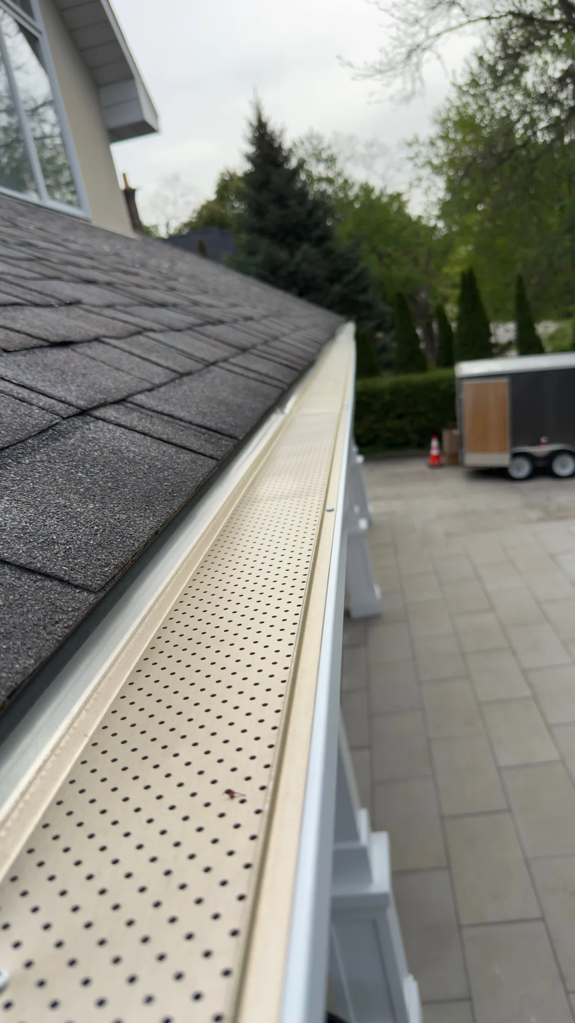 Cream perforated gutter guard close-up on a residential home in Kitchener — D&D Home Services
