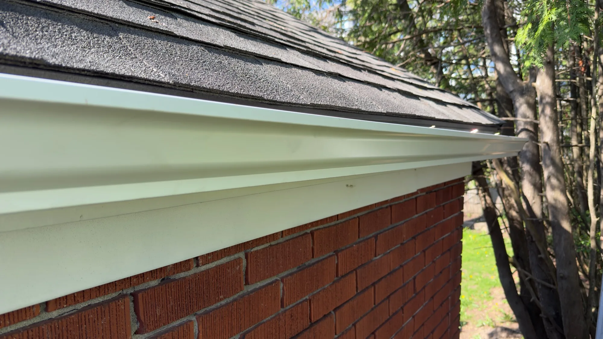 Seamless eavestrough and fascia detail on red brick home — D&D Home Services Waterloo